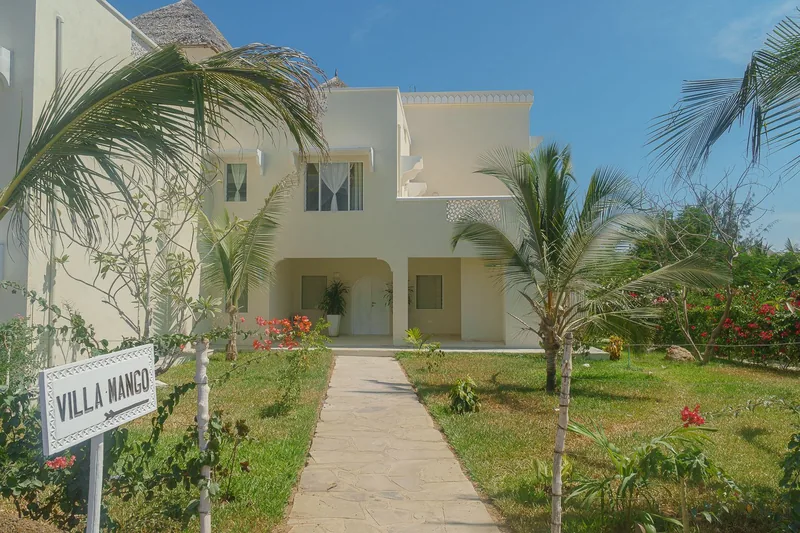 Villa Mango's exterior and garden path, with the villa's gate sign visible